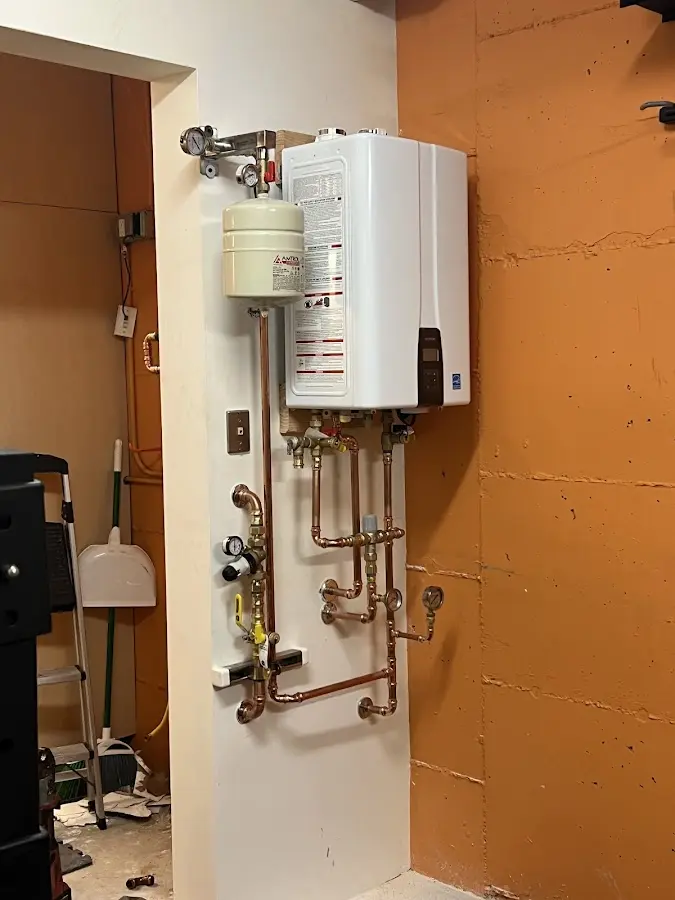 Plumbing technician inspecting water heater connections in Benbrook